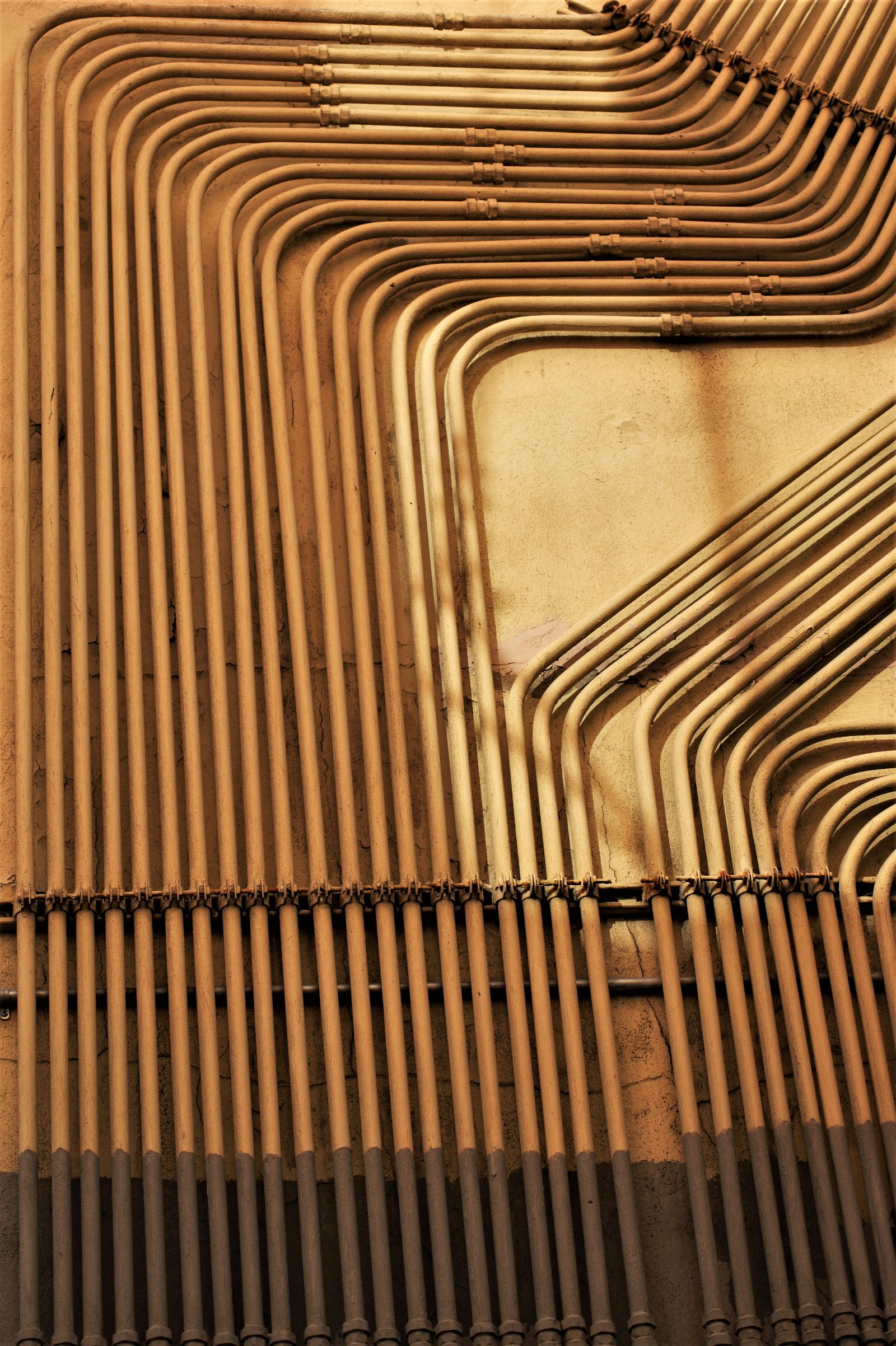 Bundled conduit runs sweeping along a wall
