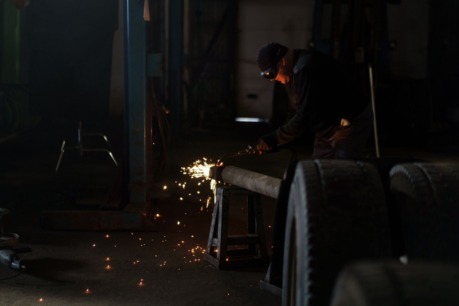 A welder at work in an industrial fabrication shop.