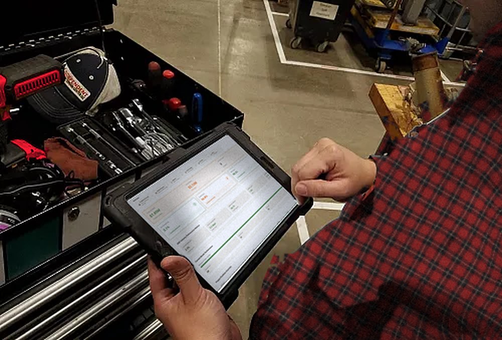 Shop manager checking ARCIFAB on a tablet next to an open toolbox