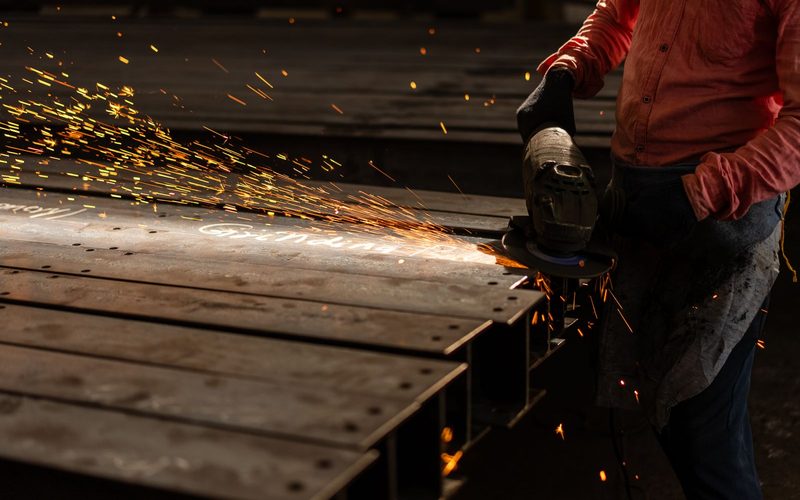 Fabricator grinding a steel beam
